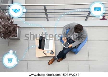 Young asian businessman using tablet, mobile phone in the office