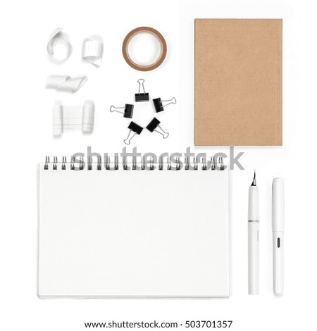 Flat layout of office object, line torn paper, brown paper tape, brown paper notebook, white notepad paper, group of black clips and white fountain pen, top view shot of photography.