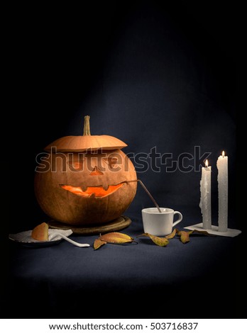 Pretty good halloween pumpkin drinks tea by candlelight. space for text