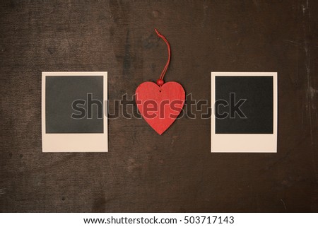Retro Vintage empty Photo frames and red wooden heart on old dark Background. Top view with copy space. Toned Love concept.