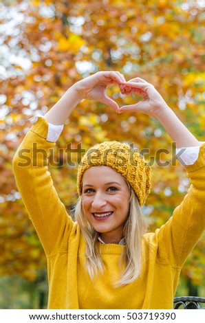 Girl in the park showing a heart with her hands