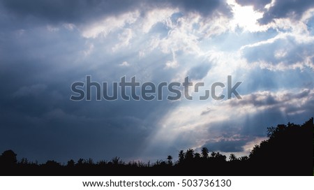 Beam of Sunlight behind dark clouds in the countryside