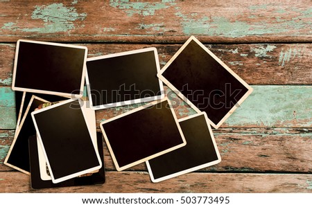 Empty instant paper photo album on wood table - vintage frame and retro style