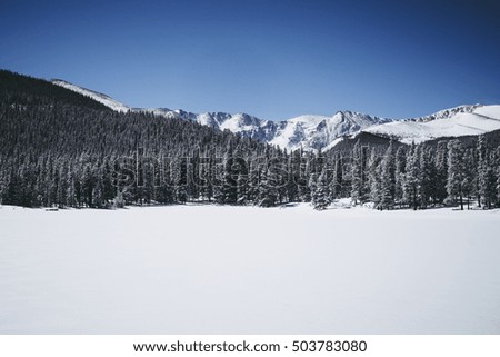 Snow covered lake with a mountain in the background
