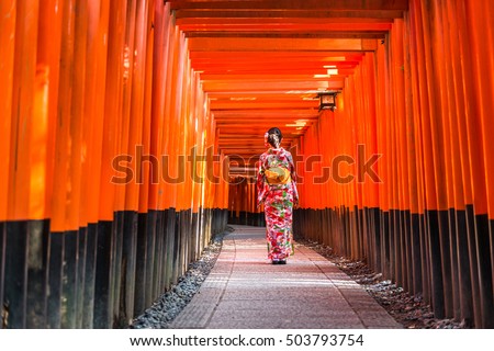 Women in kimono stand at Red Torii gates in Fushimi Inari shrine, one of famous landmarks in Kyoto, Japan Royalty-Free Stock Photo #503793754