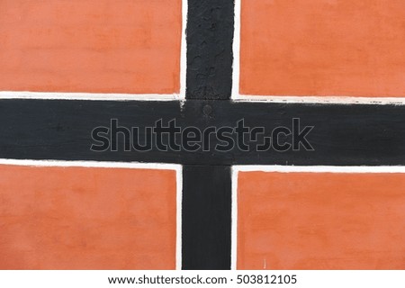 Black and white plus sign was draw on oranges brick color wall.