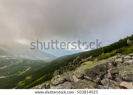Granite rock formations, fog and clouds in the Romanian Alps