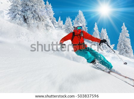 Skier skiing downhill in high mountains Royalty-Free Stock Photo #503837596