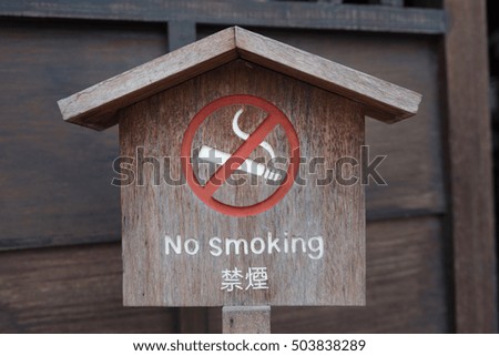 No smoking sign on wooden background in Japan.