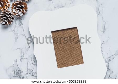 vintage white photo frame with pine cones on white marble table top,Holiday decoration card