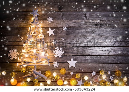 Christmas decoration on wooden background with shiny crafted tree.