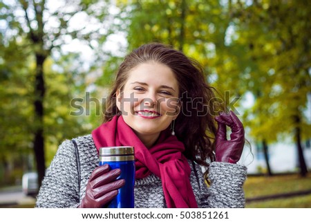 Young woman with cup of tea in the park