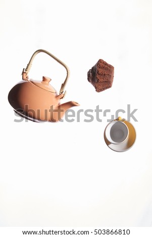 Flying teapot, cake, cup on a white background. Studio photo. Object shooting