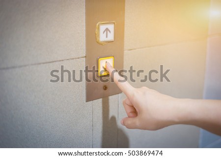Business women pressing elevator,finger presses on Red button lift. high floor.hand reaches call.touching going up sign  control panel