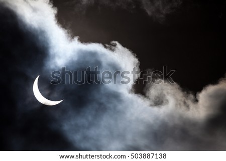 Partial solar eclipse viewed through clouds