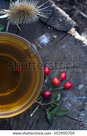 Hot tea with forest berries. Hot black tea in a transparent mug on a large frosty nature. 
View from above