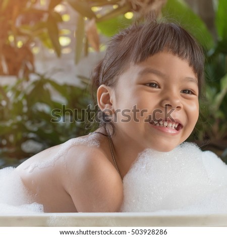 Cute asian child bathing in the garden
