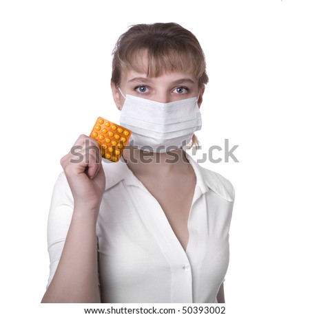 portrait of young nurse in mask holds pill in her hand