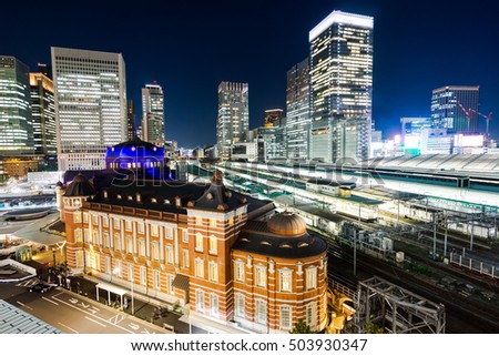 Business concept for real estate and corporate construction - panoramic modern city skyline bird eye aerial night view with tokyo station under dramatic glow and beautiful dark blue sky in Tokyo,Japan