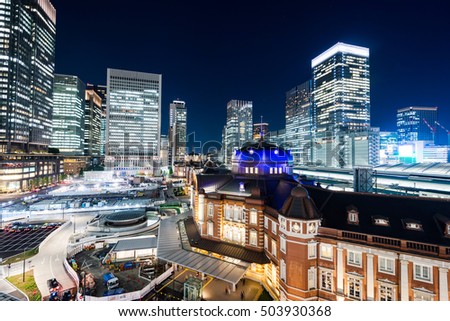 Business concept for real estate and corporate construction - panoramic modern city skyline bird eye aerial night view with tokyo station under dramatic glow and beautiful dark blue sky in Tokyo,Japan