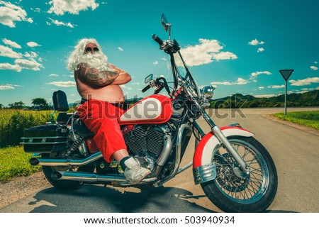 Sunburned Santa biker riding motorcycle on summer vacations