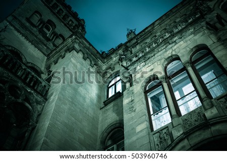 Spooky dark castle house Halloween with bright vintage window