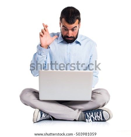 Man with laptop with his fingers crossing