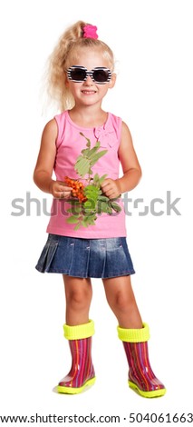 Little blonde in sunglasses, blouse, skirt and rubber boots, holding a branch with berries of mountain ash isolated on a white background.