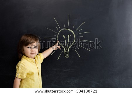 Baby boy pointing blackboard.
