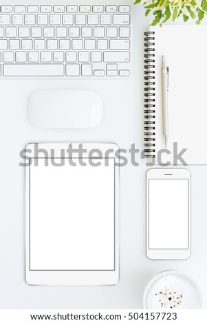 phone and tablet blank screen on white table format vertical top view