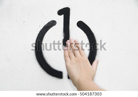 Close up of hand touching on number one in black power button symbol on a white wall. Concept energy saving start with you