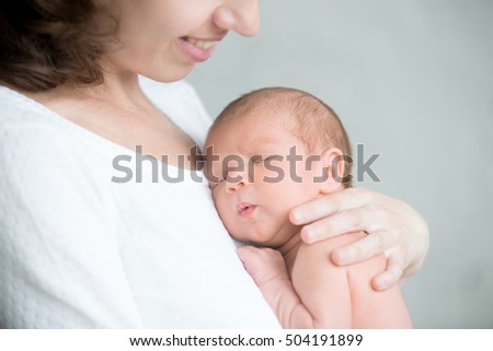 Portrait of a newborn hold close at mother s breast, close up. Family, healthy birth concept photo Royalty-Free Stock Photo #504191899