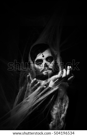 Halloween concept with young man in day of the dead mask face art