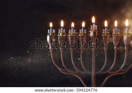 Low key Image of jewish holiday Hanukkah background with menorah (traditional candelabra) and burning candles Royalty-Free Stock Photo #504224776