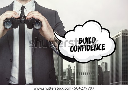 Build confidence text on blackboard with businessman
