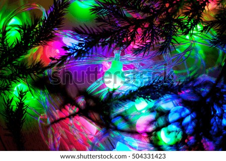 out of focus colored lights and garlands of Christmas tree branches at night. New Year, Christmas background