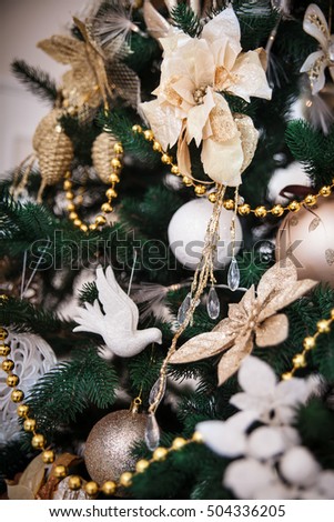 Classical ornament on a Christmas tree: birds, baubles, balls, flowers and garlands. Winter holidays