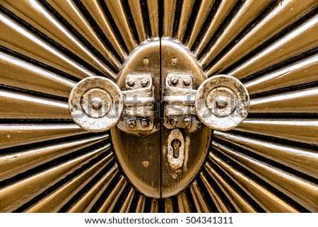 Metal door shaped sunburst with round handles.