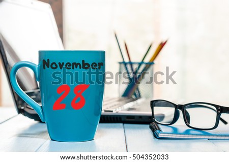November 28th. Day 28 of month, morning coffee cup with calendar on financial adviser workplace background. Autumn time. Empty space for text