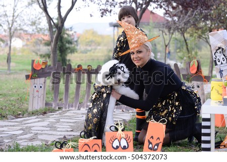 Mom and son playing with a dog in Halloween