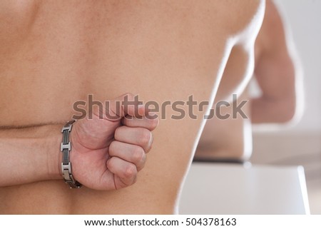 focus on the fist behind the back of a man doing arm wrestling young VS mature man