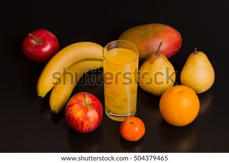 variety of fruits and orange juice on a black background, studio picture