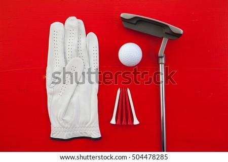 Different golf equipments on the red desk - flat lay photography