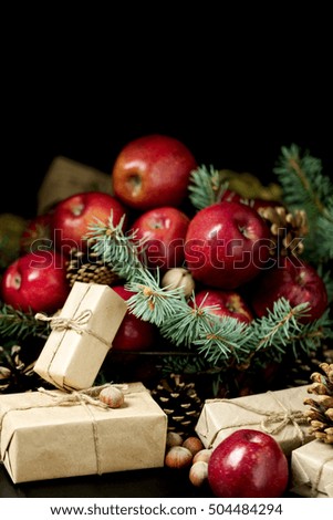 Christmas and New year. Apples with pine cones and nuts in a basket with fir branches. Gifts and candles.