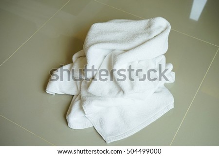 Stacked white spa cloth beach towels on marble  background.                         