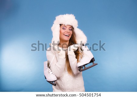 Winter, sport, clothing concept. Smiling winter girl with skates. Studio picture with beautiful lady.