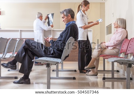Patients and doctors speaking inside hospital waiting room. Royalty-Free Stock Photo #504507346