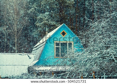 Wooden roof of old hut in the forest in snowfall