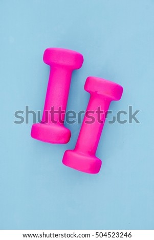 A studio photo of a pink gym dumbbell