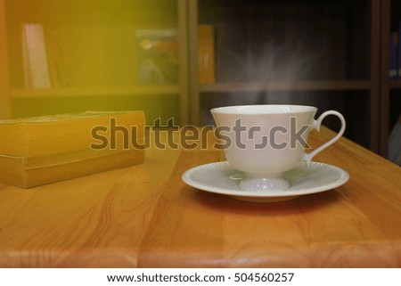 Cup of coffee on the wooden table in the library,copy space for text against,Vintage effect style pictures